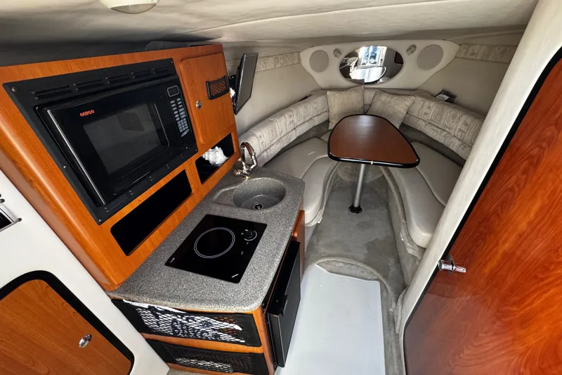 Slide: The Image of Interior of 2004 Crownline 250 CR boat with kitchenette and TV. - 53