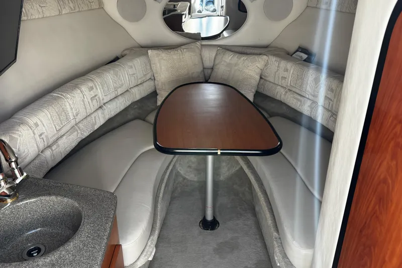 Slide: The Image of Interior of 2004 Crownline 250 CR boat showing a small window and wooden cabinet. - 54