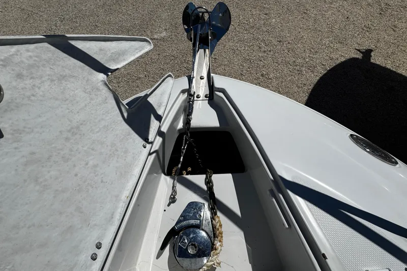 Slide: The Image of 2004 Crownline 250 CR cabin interior with cushioned seating and wooden table. - 57