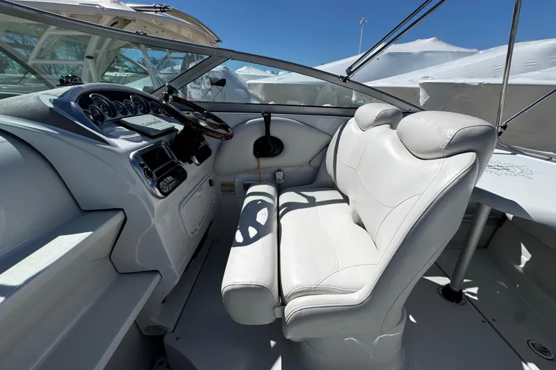 Slide: The Image of 2004 Crownline 250 CR boat interior with white seating and steering wheel. - 69
