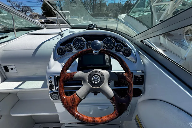 Slide: The Image of 2004 Crownline 250 CR boat interior with gray seating and compass-themed table. - 72