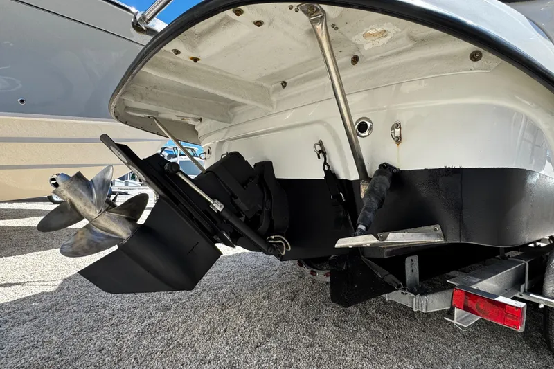 Slide: The Image of 2004 Crownline 250 CR boat with black canopy, docked on a trailer. - 8