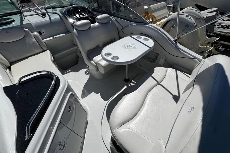 Slide: The Image of 2004 Crownline 250 CR boat interior with white seating and modern dashboard. - 90