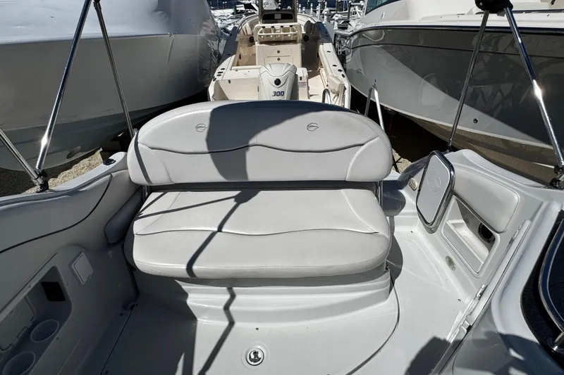 Slide: The Image of 2004 Crownline 250 CR boat interior with dashboard and steering wheel, parked in a marina. - 91