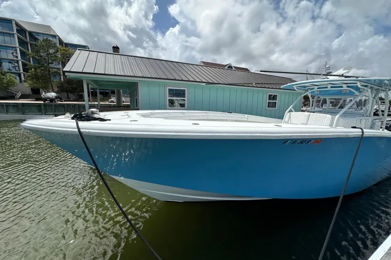 Slide: The Image of 2009 Yellowfin 42 Offshore boat docked, featuring a sleek blue hull and modern design. - 1