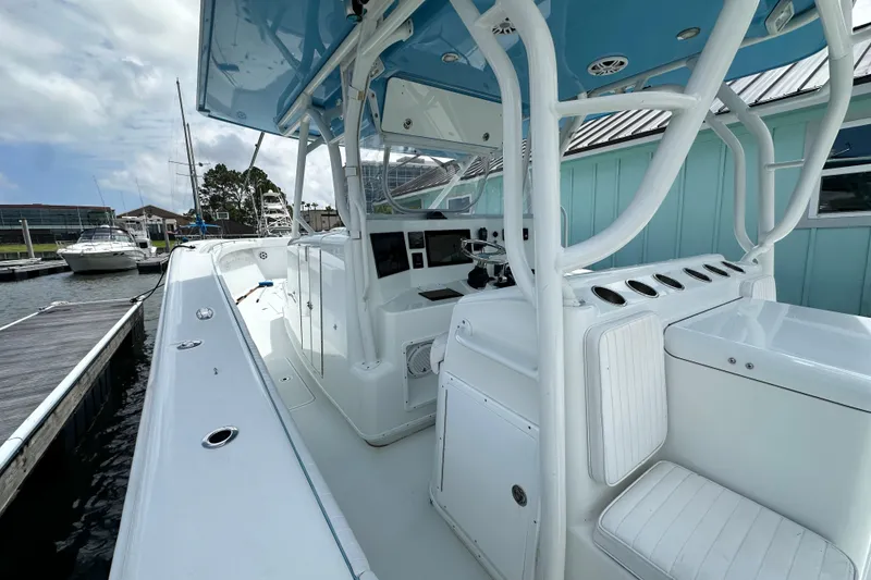 Slide: The Image of 2009 Yellowfin 42 Offshore boat docked, showcasing spacious deck and modern helm. - 11