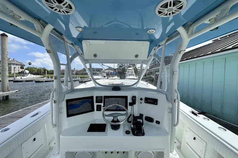 Slide: The Image of 2009 Yellowfin 42 Offshore boat helm with navigation screens and controls at marina. - 14