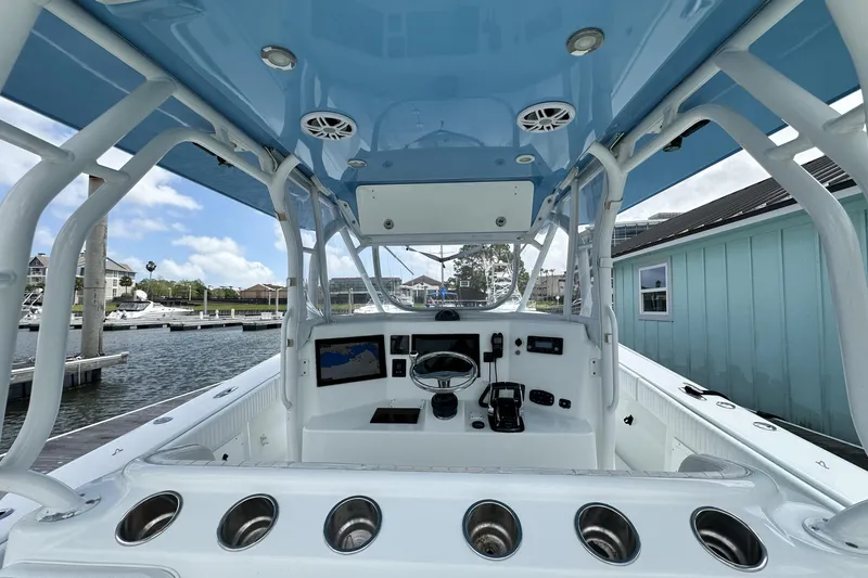 Slide: The Image of 2009 Yellowfin 42 Offshore boat cockpit with blue canopy and marina view. - 16
