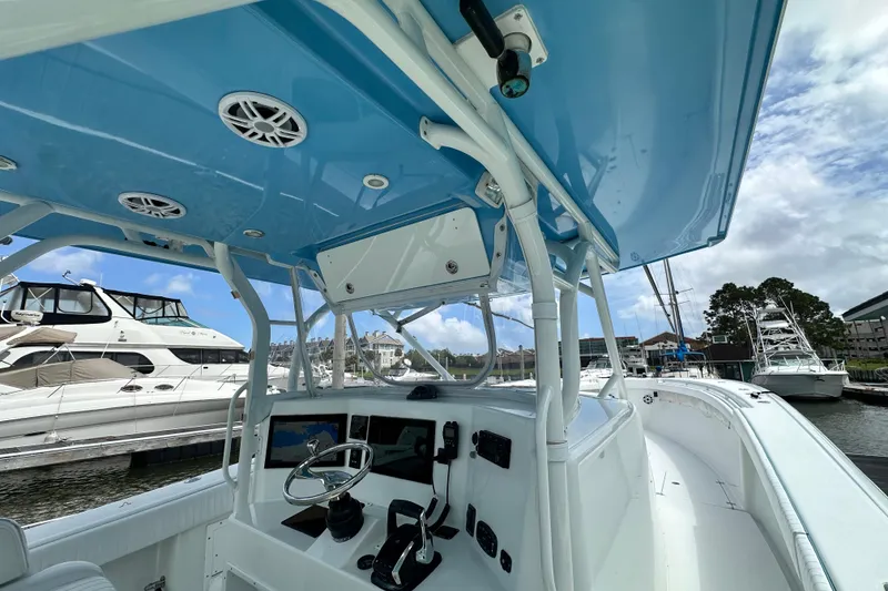 Slide: The Image of 2009 Yellowfin 42 Offshore boat interior with blue canopy and docked yachts in background. - 18