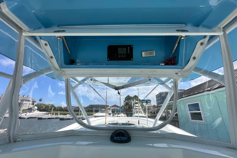 Slide: The Image of 2009 Yellowfin 42 Offshore boat interior with blue canopy and marina view. - 19