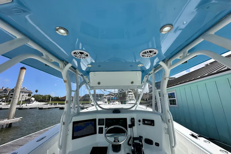 Slide: The Image of 2009 Yellowfin 42 Offshore boat interior with blue canopy and modern controls at marina. - 20