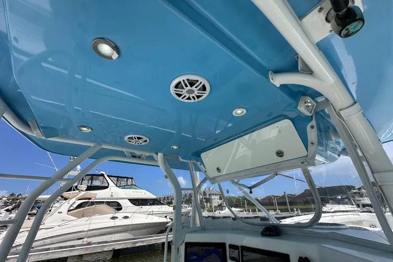 Slide: The Image of Interior view of a 2009 Yellowfin 42 Offshore boat with blue ceiling and speakers. - 22