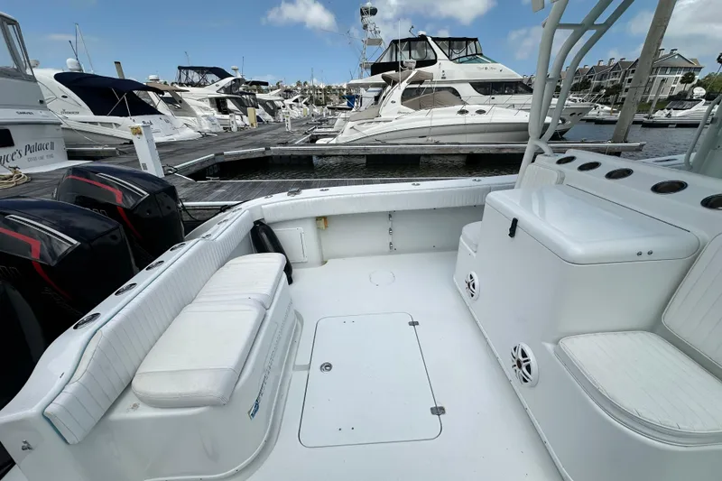 Slide: The Image of 2009 Yellowfin 42 Offshore boat interior at marina, featuring seating and storage. - 28