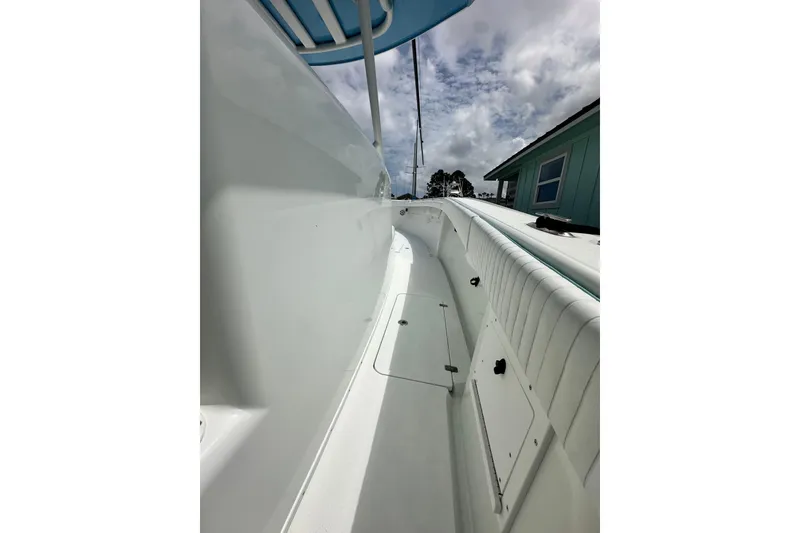 Slide: The Image of 2009 Yellowfin 42 Offshore boat deck, showcasing sleek white design under cloudy sky. - 32