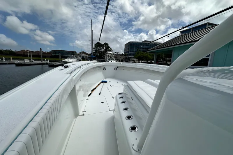 Slide: The Image of 2009 Yellowfin 42 Offshore boat docked, showcasing spacious deck and seating under cloudy sky. - 40