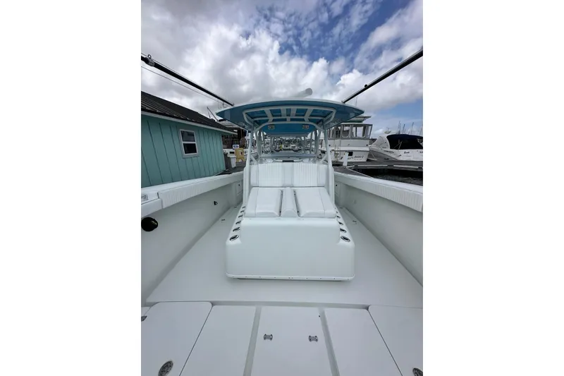 Slide: The Image of 2009 Yellowfin 42 Offshore boat with spacious deck and seating, docked under cloudy skies. - 44