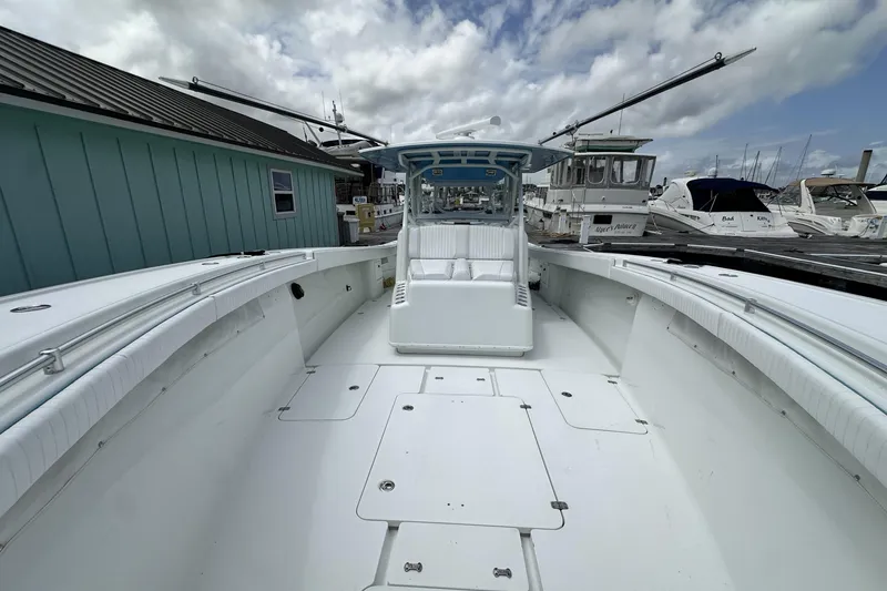 Slide: The Image of 2009 Yellowfin 42 Offshore boat docked, showcasing spacious deck and seating area. - 45