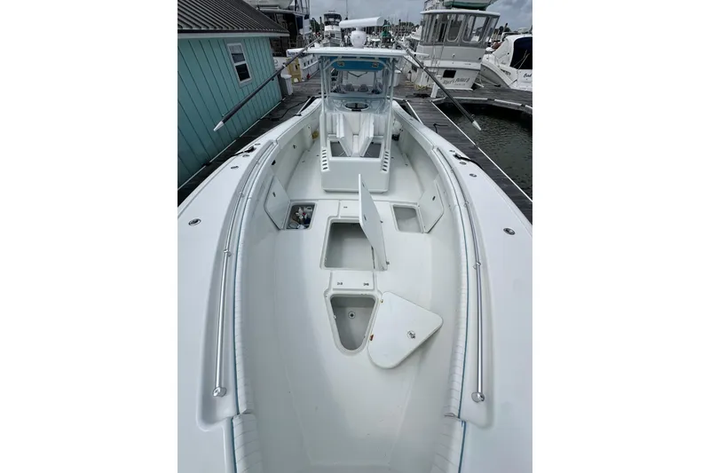 Slide: The Image of 2009 Yellowfin 42 Offshore boat docked, showcasing spacious deck and storage compartments. - 46