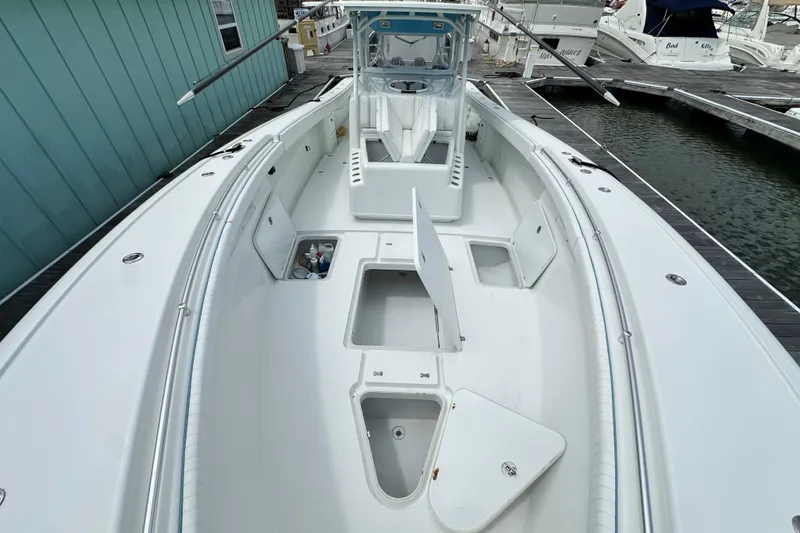 Slide: The Image of 2009 Yellowfin 42 Offshore boat docked, showcasing spacious deck and storage compartments. - 47