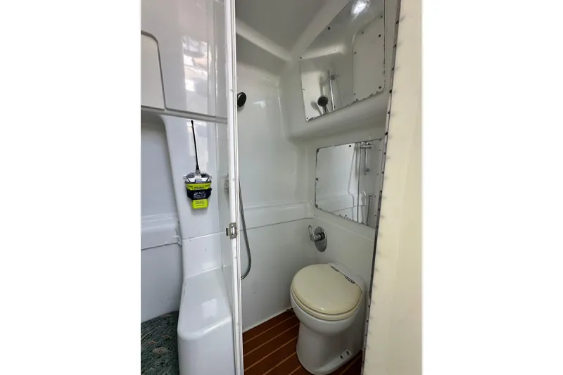 Slide: The Image of 2009 Yellowfin 42 Offshore boat bathroom with toilet, shower, and mirror. - 65