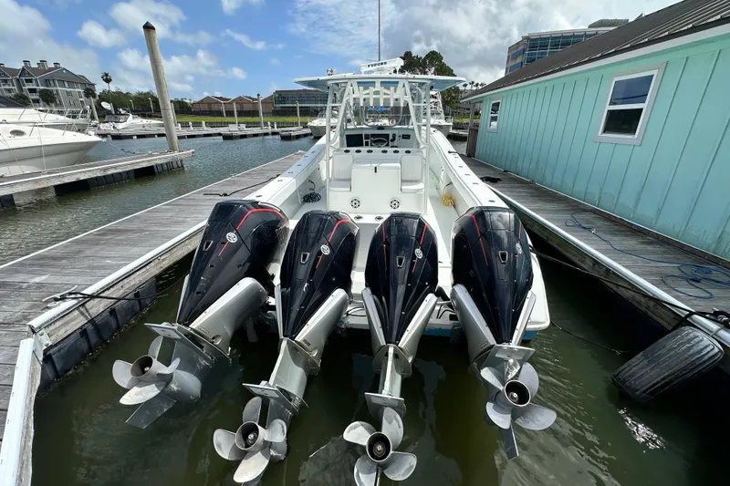 Slide: The Image of 2009 Yellowfin 42 Offshore boat docked, featuring four powerful outboard engines. - 7