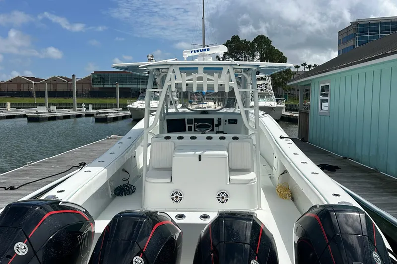 Slide: The Image of 2009 Yellowfin 42 Offshore boat docked, featuring triple outboard engines and spacious deck. - 8