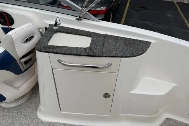 Slide: The Image of 2010 Chaparral Sunesta 244 boat interior with sink and storage cabinet. - 15