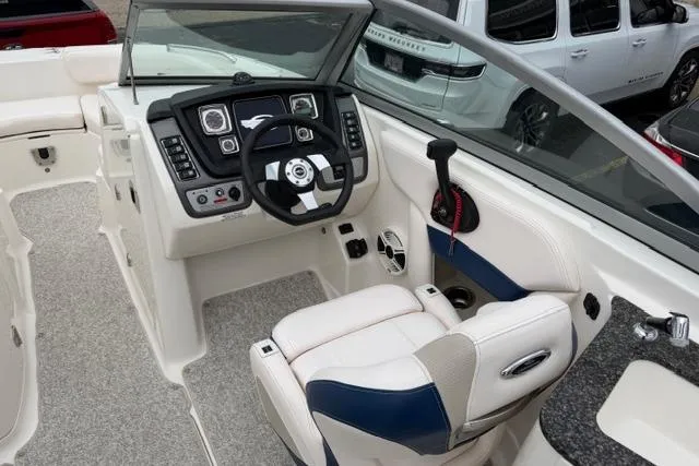 Slide: The Image of 2010 Chaparral Sunesta 244 boat cockpit with steering wheel, control panel, and seating. - 18