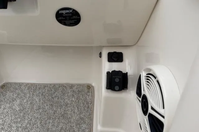 Slide: The Image of Interior view of a 2010 Chaparral Sunesta 244 boat, featuring speaker and carpeted flooring. - 24