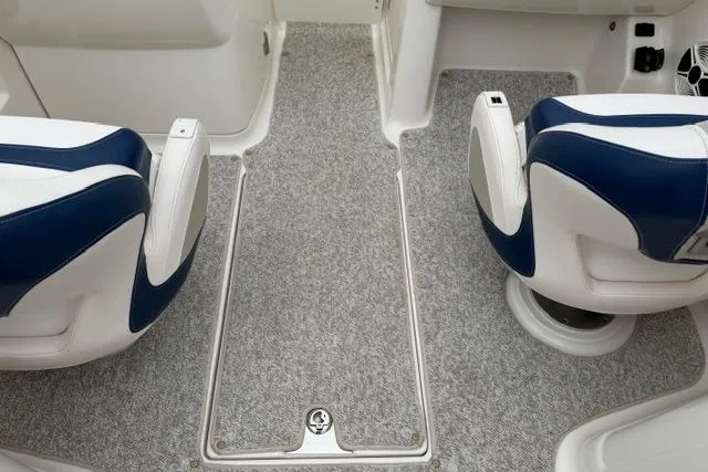 Slide: The Image of 2010 Chaparral Sunesta 244 boat interior with blue and white seating and gray carpet. - 26