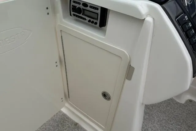 Slide: The Image of 2010 Chaparral Sunesta 244 boat interior with storage compartment and audio system. - 28