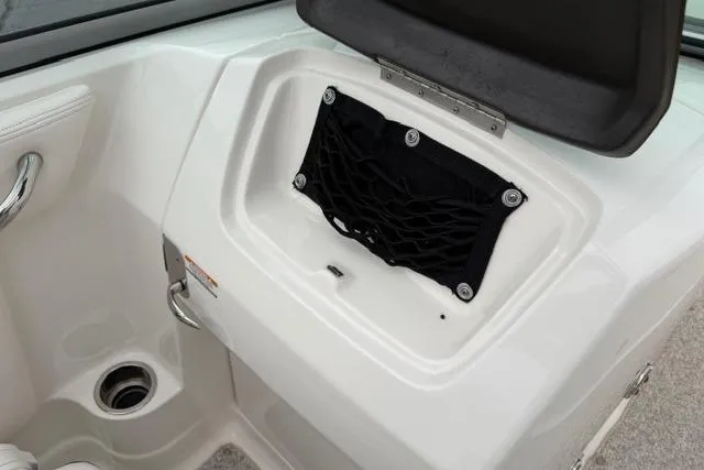 Slide: The Image of 2010 Chaparral Sunesta 244 boat interior storage compartment with netting and cup holder. - 45