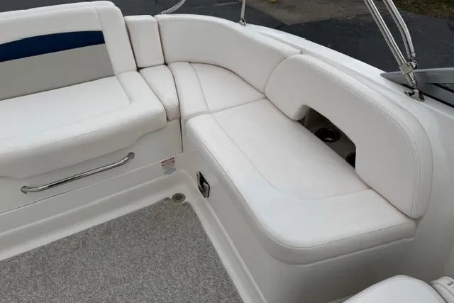 Slide: The Image of 2010 Chaparral Sunesta 244 boat interior with white cushioned seating and stainless steel accents. - 48