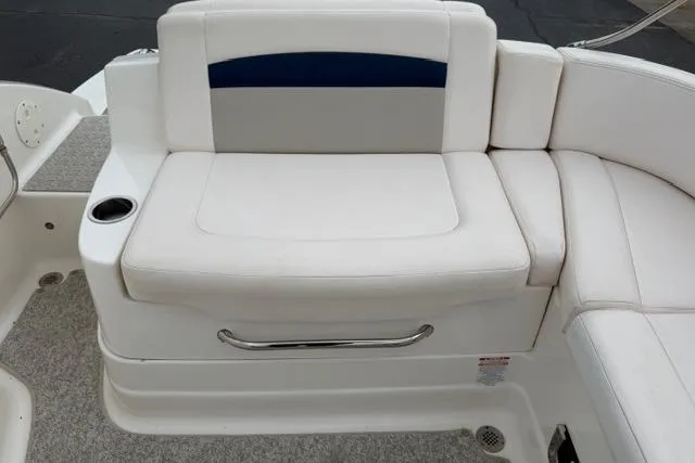 Slide: The Image of 2010 Chaparral Sunesta 244 boat seating area with white upholstery and cup holder. - 50