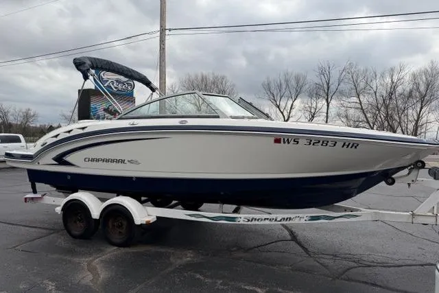 Slide: The Image of 2010 Chaparral Sunesta 244 boat on trailer, parked outdoors under cloudy sky. - 8