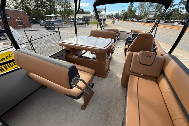 Slide: The Image of 2026 Avalon Catalina Entertainer Funship interior with tan seating and table, parked outdoors. - 31