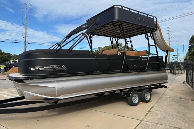 Slide: The Image of 2026 Avalon Catalina Entertainer Funship pontoon boat on trailer, featuring sleek black design. - 59