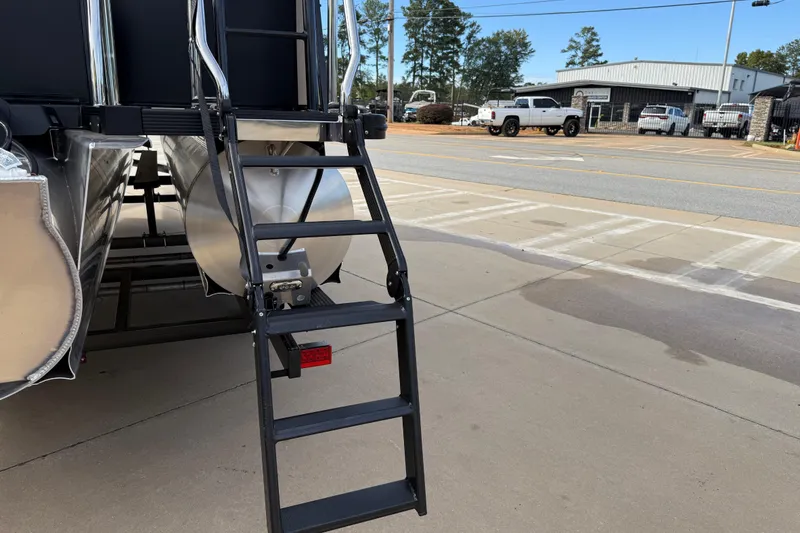 Slide: The Image of Ladder on 2026 Avalon Catalina Entertainer Funship pontoon boat, parked on concrete surface. - 7