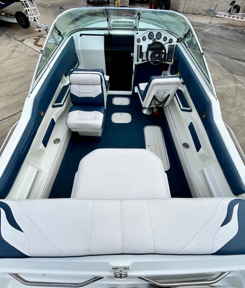 Slide: The Image of Interior of a 1993 Mariah MX20 C boat with blue and white seating. - 10