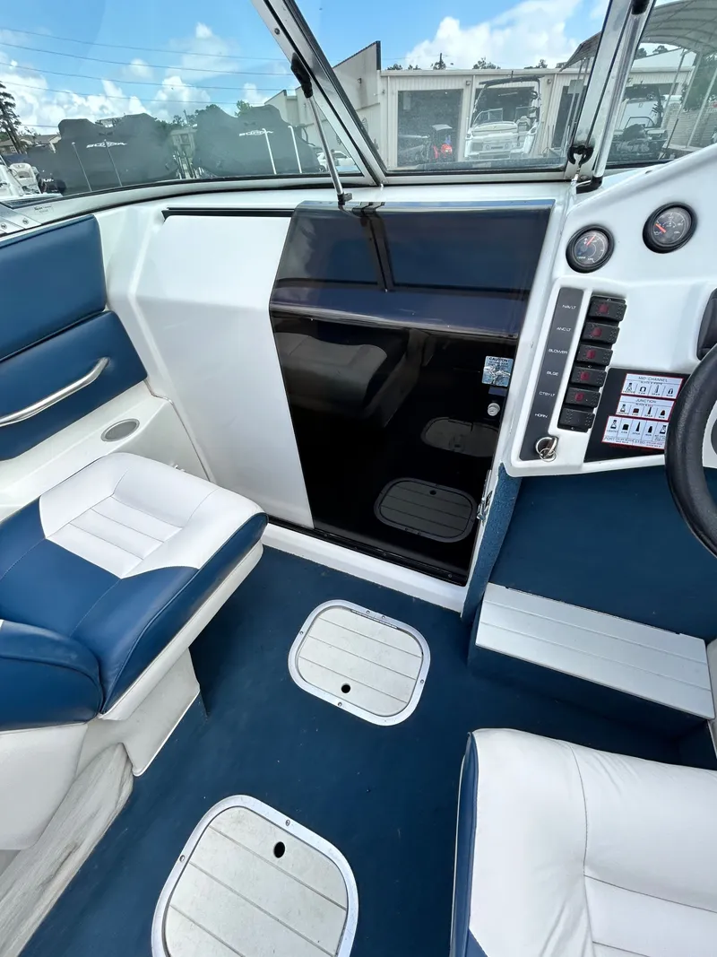 Slide: The Image of Interior of a 1993 Mariah MX20 C boat with blue seating. - 12