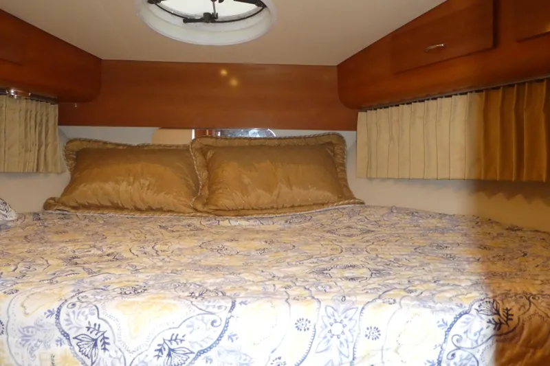 Slide: The Image of 2006 Carver 366 Motor Yacht bedroom with cozy bedding and wood accents. - 20
