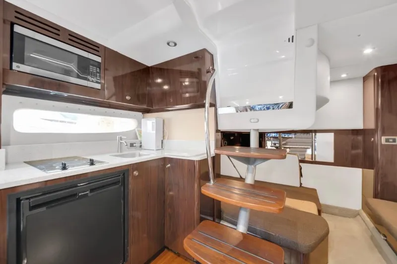 Slide: The Image of 2015 Sea Ray Sundancer 350 interior with modern kitchen and stylish wooden stairs. - 10