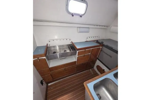 Slide: The Image of 1986 Bill Lee Yachts Santa Cruz 50 galley with wooden cabinetry and stainless steel sink. - 13