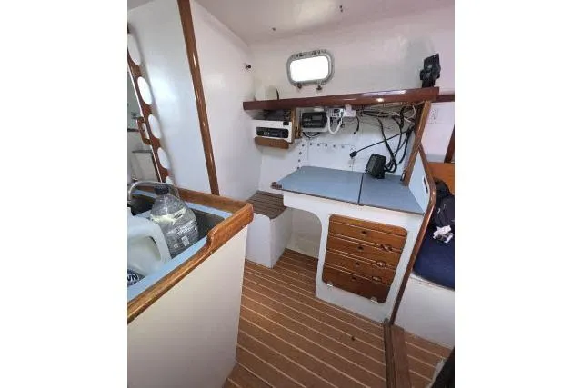 Slide: The Image of 1986 Bill Lee Yachts Santa Cruz 50 interior with navigation station and wooden flooring. - 16