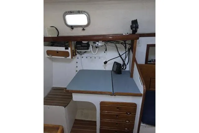 Slide: The Image of 1986 Bill Lee Yachts Santa Cruz 50 interior with navigation station and storage drawers. - 17