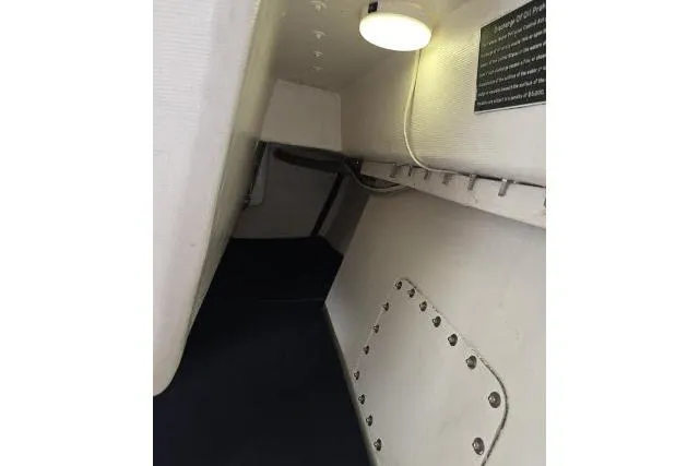 Slide: The Image of Interior view of a 1986 Bill Lee Yachts Santa Cruz 50, featuring a compact cabin space. - 22