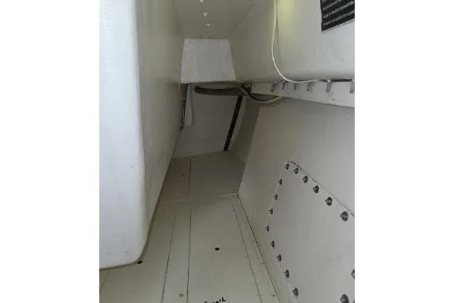 Slide: The Image of Interior view of a 1986 Bill Lee Yachts Santa Cruz 50 sailboat, showcasing white cabin space. - 23