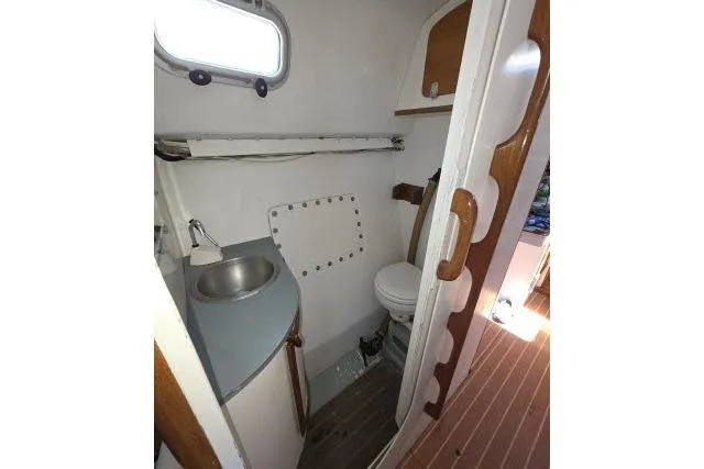 Slide: The Image of Compact bathroom in 1986 Bill Lee Yachts Santa Cruz 50, featuring sink and toilet. - 24