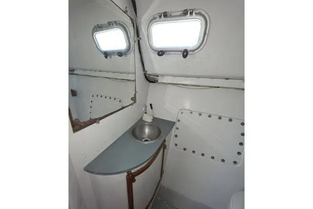 Slide: The Image of Bathroom interior of 1986 Bill Lee Yachts Santa Cruz 50, featuring sink and porthole windows. - 26
