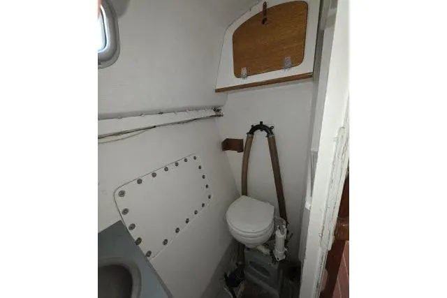 Slide: The Image of Compact bathroom in 1986 Bill Lee Yachts Santa Cruz 50 sailboat, featuring a marine toilet. - 27